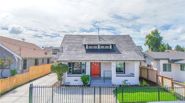 bungalow-style home with a fenced front yard and a front yard