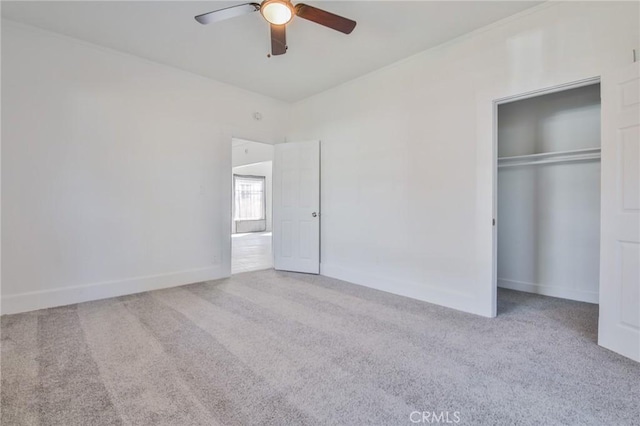 unfurnished bedroom with carpet, a closet, ceiling fan, and baseboards