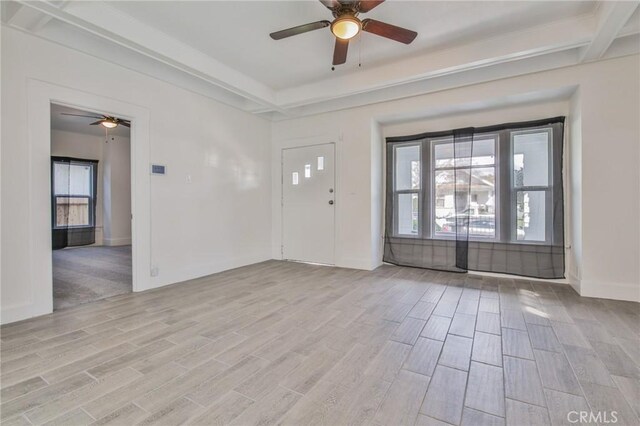 foyer entrance with ceiling fan, a raised ceiling, and wood finish floors