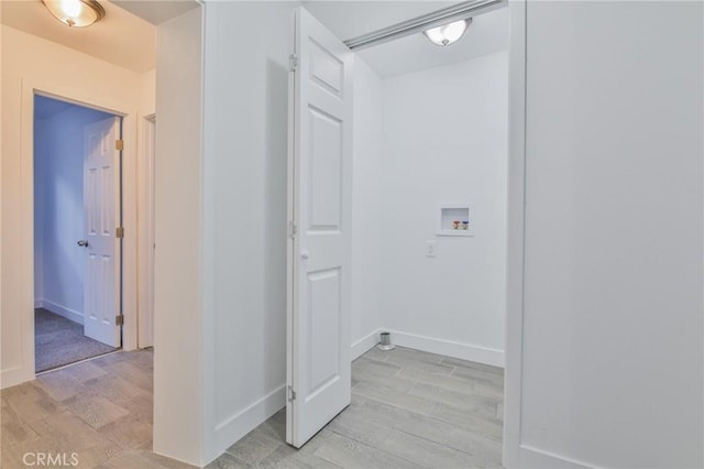 washroom featuring hookup for a washing machine, laundry area, light wood-style flooring, and baseboards