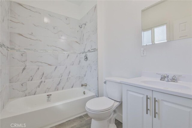 bathroom with toilet, shower / bath combination, wood finished floors, and vanity