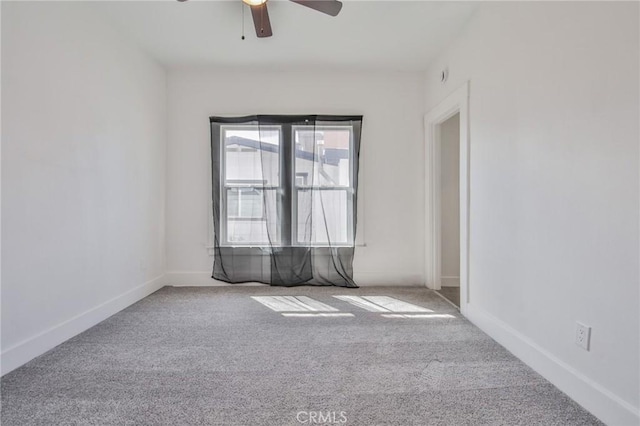 spare room with carpet, baseboards, and a ceiling fan