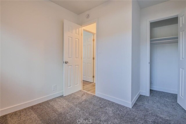 unfurnished bedroom featuring a closet, carpet, and baseboards