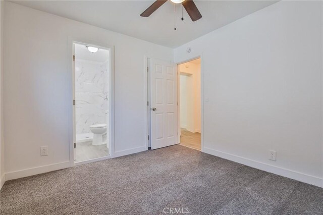 unfurnished bedroom with carpet floors, connected bathroom, baseboards, and ceiling fan