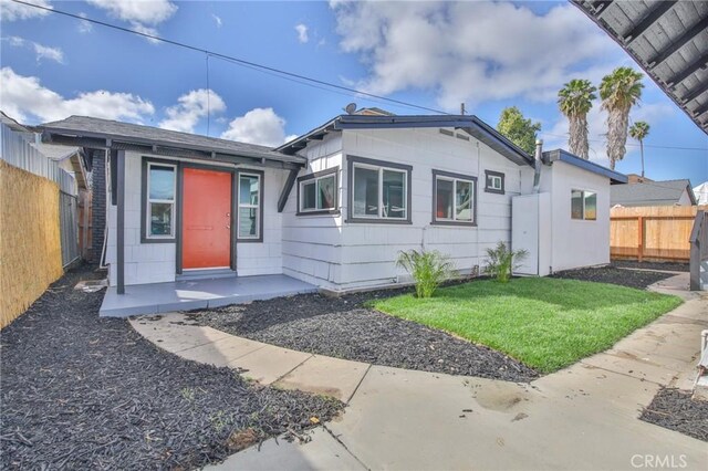 bungalow-style home with a fenced backyard and a front yard