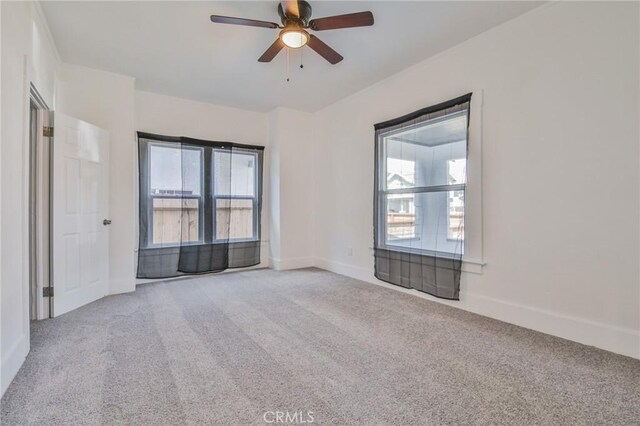 unfurnished room with ceiling fan, carpet floors, and baseboards