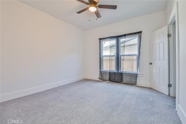 empty room featuring ceiling fan, carpet, and baseboards