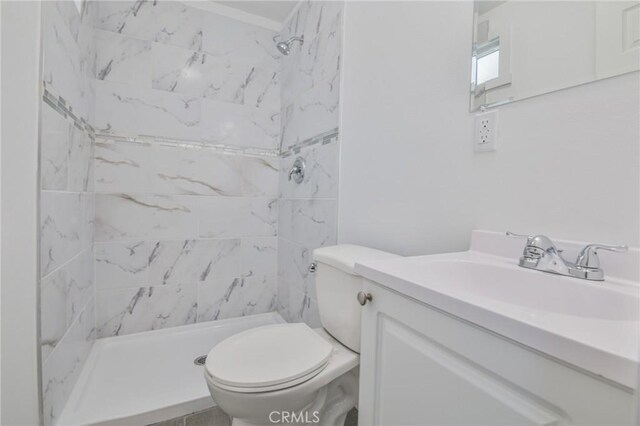 bathroom with a stall shower, vanity, and toilet