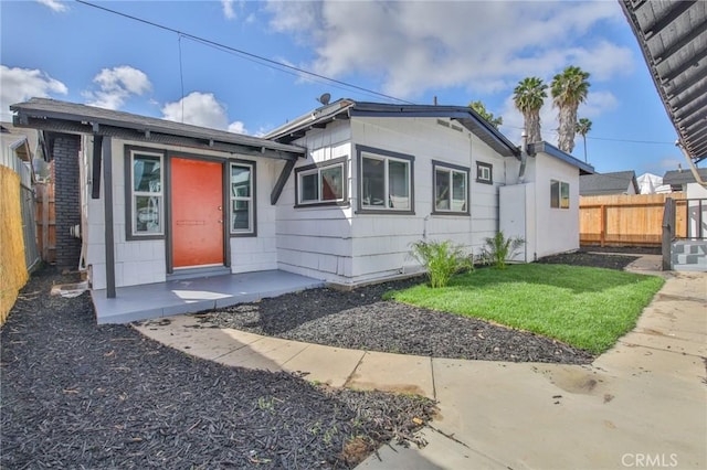 bungalow-style home featuring fence and a front lawn