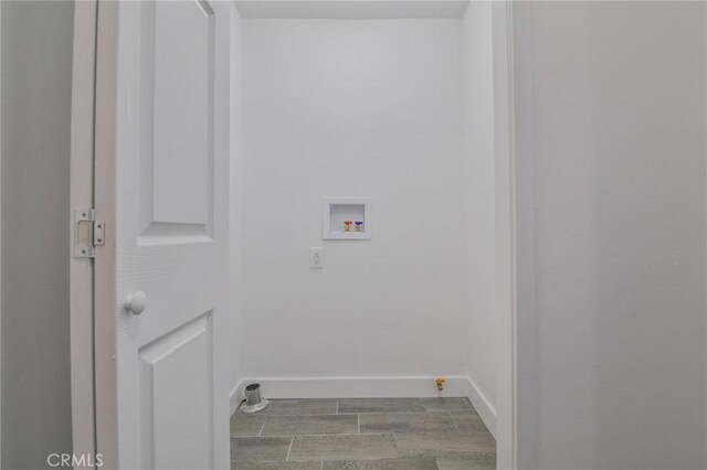 washroom with laundry area, wood finish floors, hookup for a washing machine, and baseboards