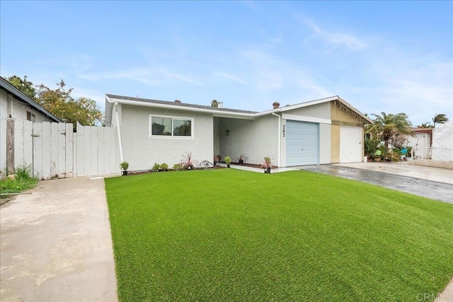 view of front of house with stucco siding, a front yard, fence, a garage, and driveway