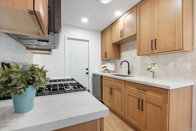 kitchen with light wood finished floors, light countertops, decorative backsplash, a sink, and dishwasher