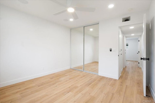 unfurnished bedroom with light wood-style floors, baseboards, a closet, and recessed lighting