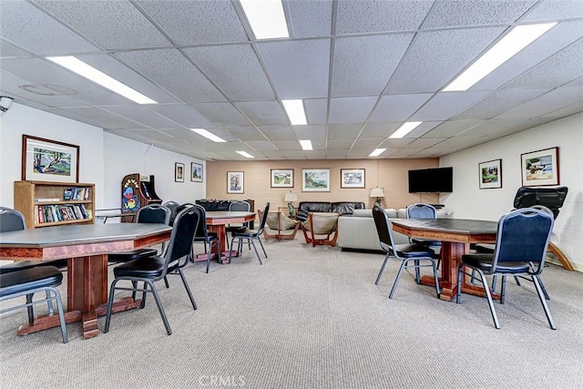 carpeted dining area with a drop ceiling