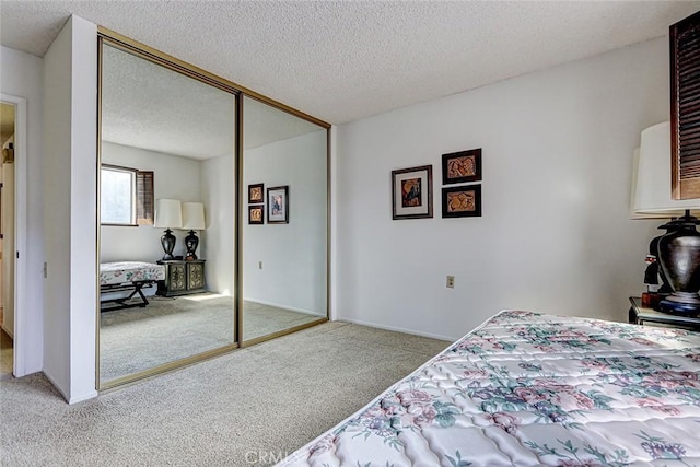 carpeted bedroom with a closet, baseboards, and a textured ceiling