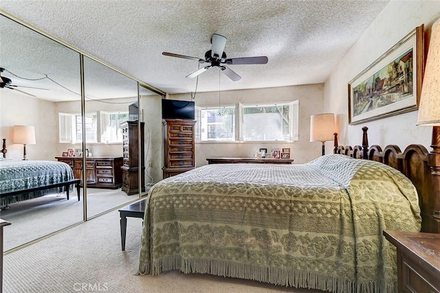 carpeted bedroom with a textured ceiling and ceiling fan