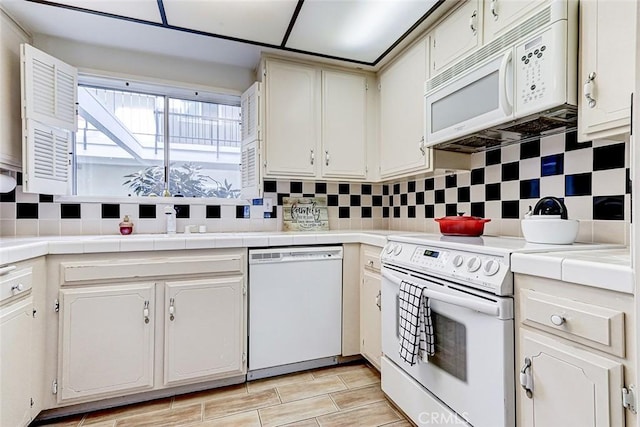 kitchen featuring decorative backsplash, tile countertops, and white appliances