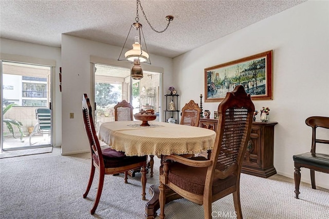 dining area with baseboards, plenty of natural light, light colored carpet, and a textured ceiling