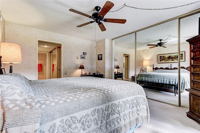 carpeted bedroom featuring a closet, a textured ceiling, and ceiling fan