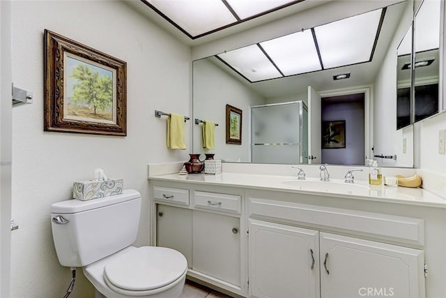 bathroom with toilet, a stall shower, and vanity