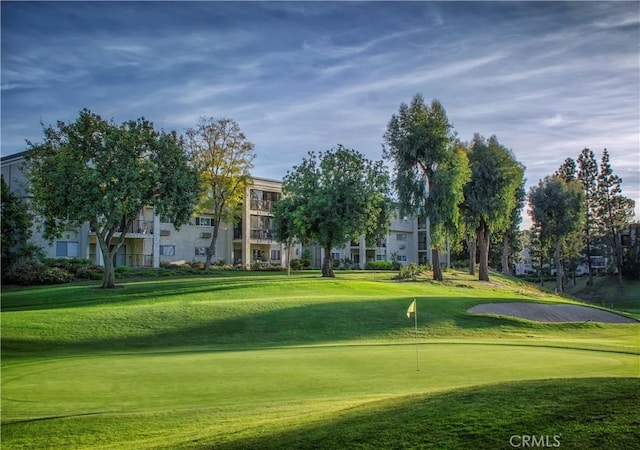 view of community featuring a yard and view of golf course