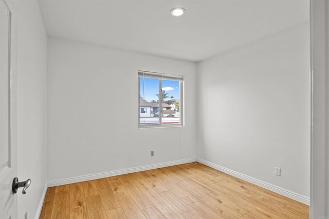 empty room featuring light wood-type flooring and baseboards