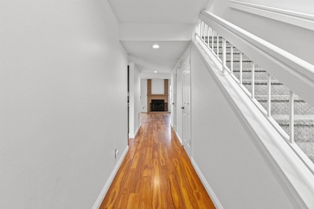 hallway featuring stairs, recessed lighting, wood finished floors, and baseboards