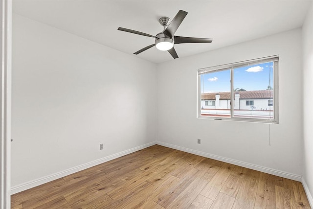 empty room featuring ceiling fan, baseboards, and light wood-style floors