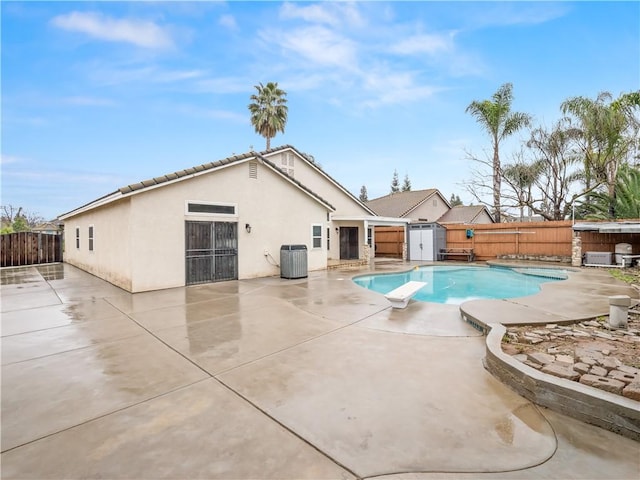 view of pool featuring a patio, central AC unit, a fenced backyard, a diving board, and a fenced in pool