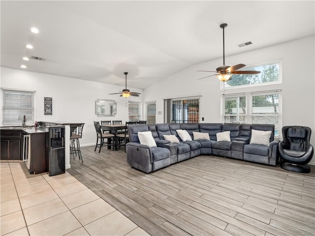 living area with vaulted ceiling, light wood-type flooring, visible vents, and recessed lighting