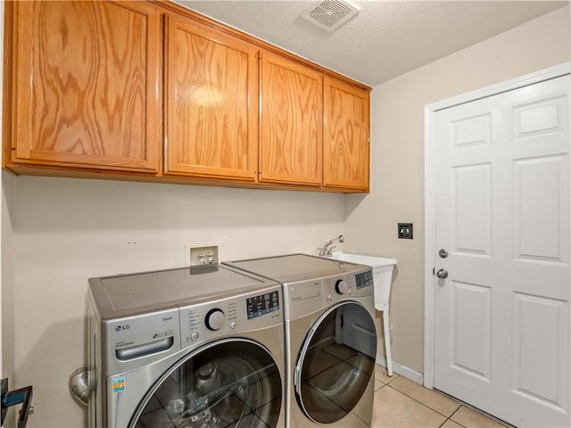 laundry room with light tile patterned floors, cabinet space, visible vents, washing machine and dryer, and baseboards