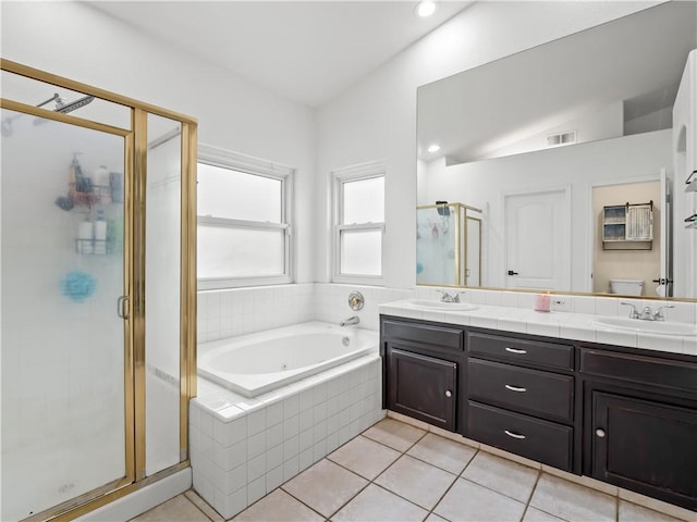 bathroom with a bath, a shower stall, double vanity, and a sink