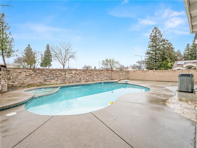 view of pool featuring a pool with connected hot tub, a patio area, a fenced backyard, and central AC unit