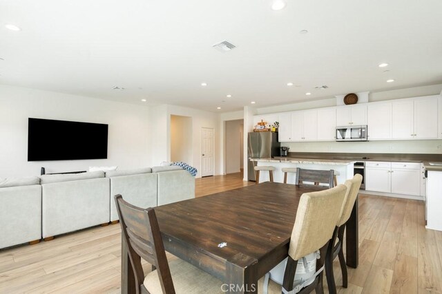 dining room featuring light wood-type flooring, visible vents, and recessed lighting