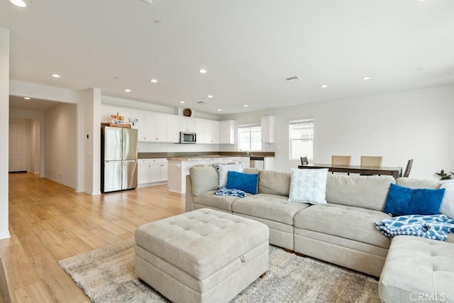 living area featuring light wood-style flooring and recessed lighting