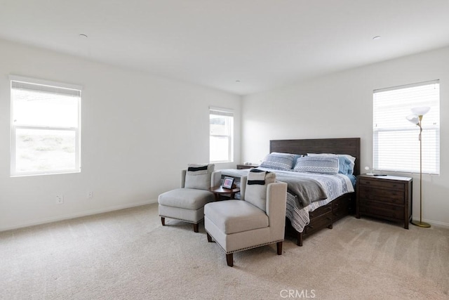 bedroom with light colored carpet and baseboards