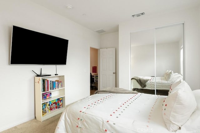 carpeted bedroom featuring a closet, visible vents, and baseboards