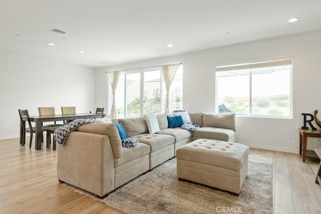 living area featuring light wood-style floors, recessed lighting, visible vents, and baseboards