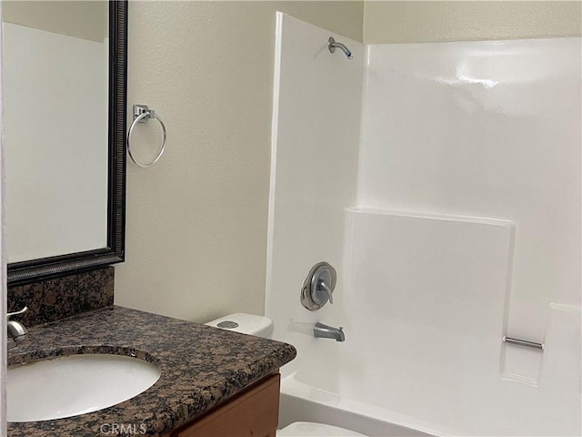 full bathroom featuring washtub / shower combination, vanity, and toilet