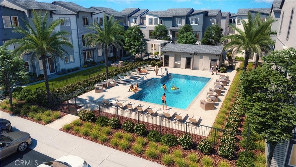 community pool with a residential view, fence, and a patio