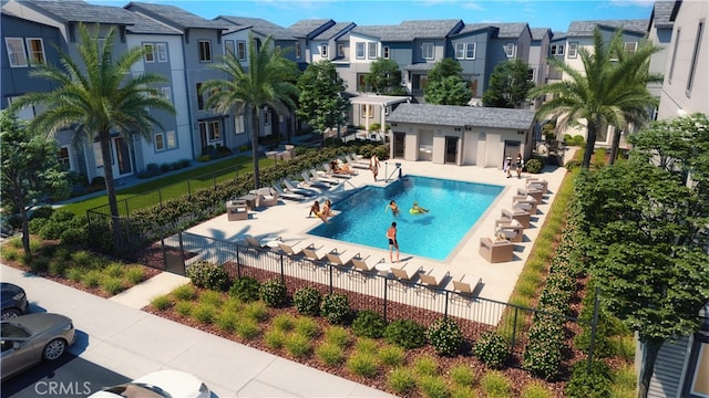 community pool with a residential view, fence, and a patio