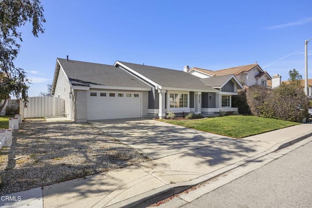 view of front of home featuring concrete driveway, a front lawn, an attached garage, and fence