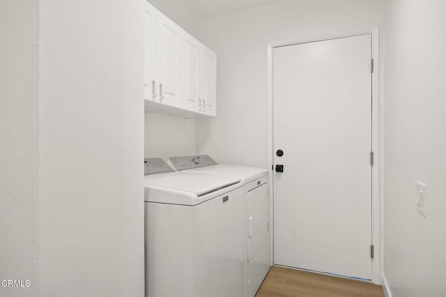 laundry room with light wood-style flooring, cabinet space, and washer and clothes dryer