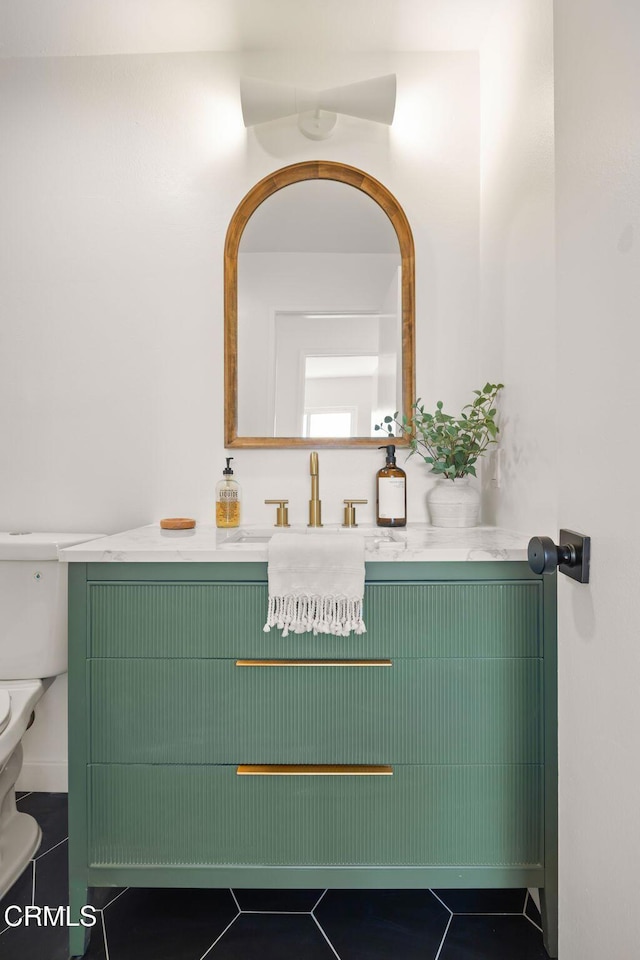 bathroom with toilet, tile patterned floors, and vanity