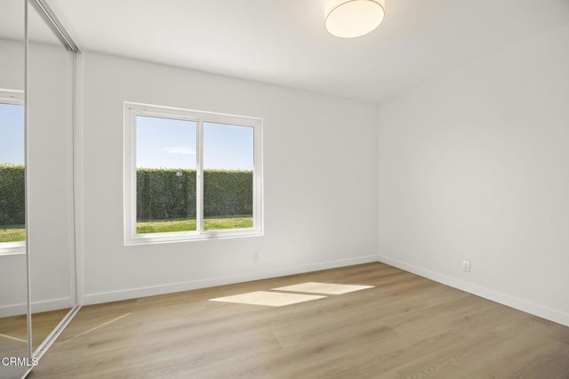 empty room with light wood-style flooring and baseboards