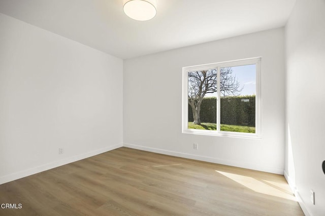 empty room featuring wood finished floors and baseboards