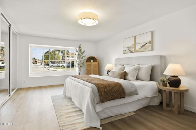 bedroom with wood finished floors and baseboards