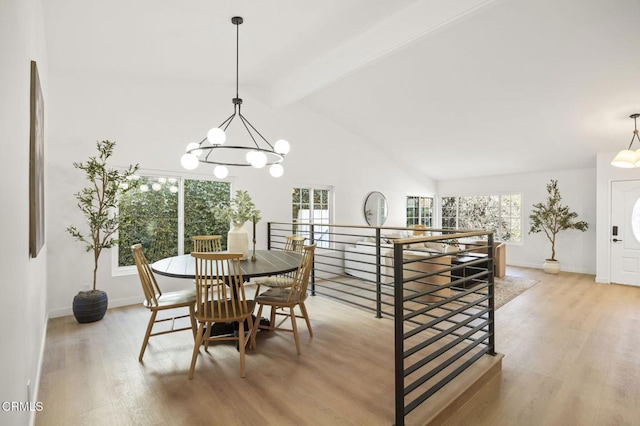 dining space featuring light wood-style floors, a notable chandelier, lofted ceiling with beams, and baseboards