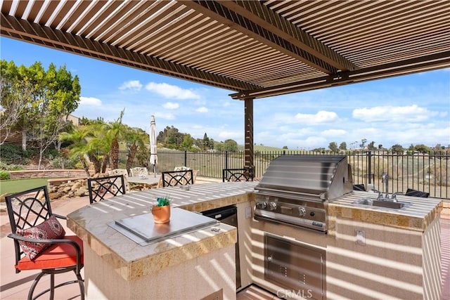 view of patio / terrace featuring an outdoor kitchen, fence, grilling area, and a pergola