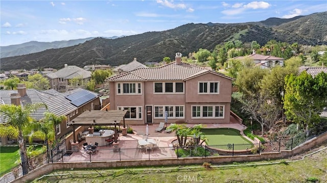 8072 Soft Winds Dr, Corona, CA 92883 - back of house featuring a chimney, a fenced backyard, a mountain view, and a patio area